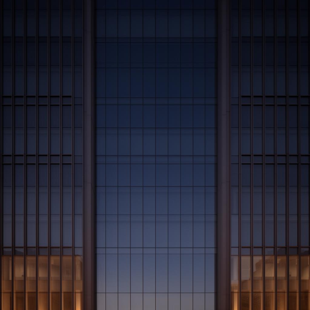 Architectural detail of a glass and steel tower against twilight sky